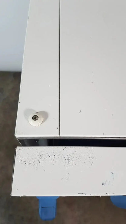 White plastic screw cap with central metallic threaded hole on the corner of thermo scientific heratherm igs60 incubator cabinet