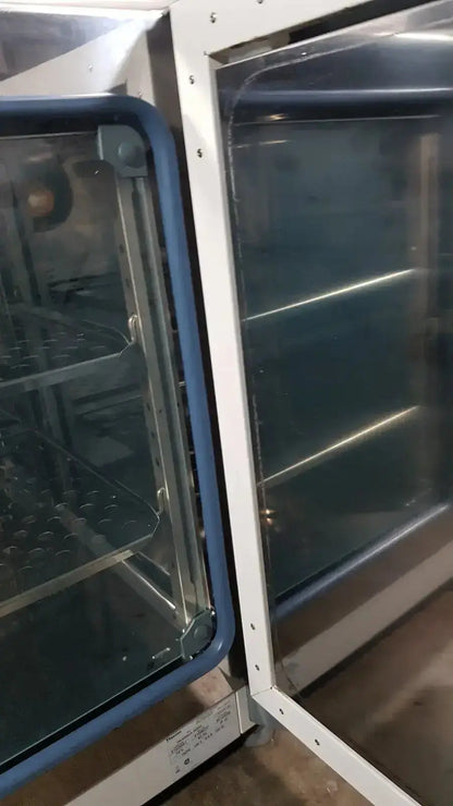Blue-framed glass-door thermo scientific heratherm igs60 incubator with stainless steel interior shelves for lab use