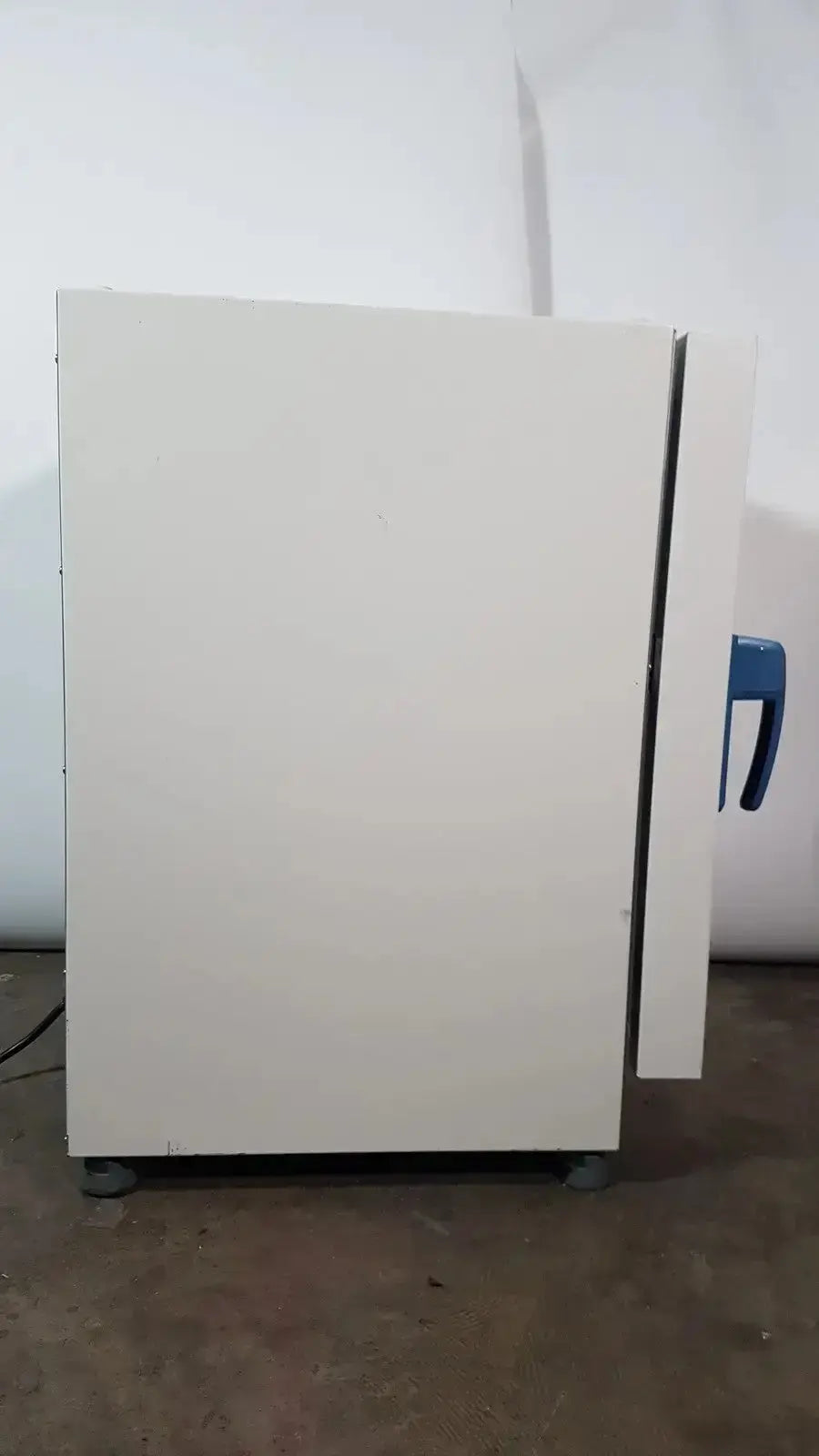 White laboratory oven with blue handle and gray casters of thermo scientific heratherm igs60 incubator model