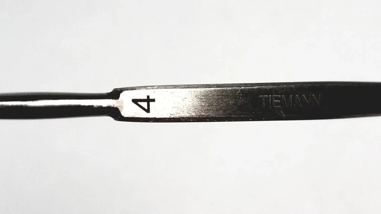 Black metal Tiemann surgical dermal curette size 4 with silver stainless steel cutting edge medical equipment