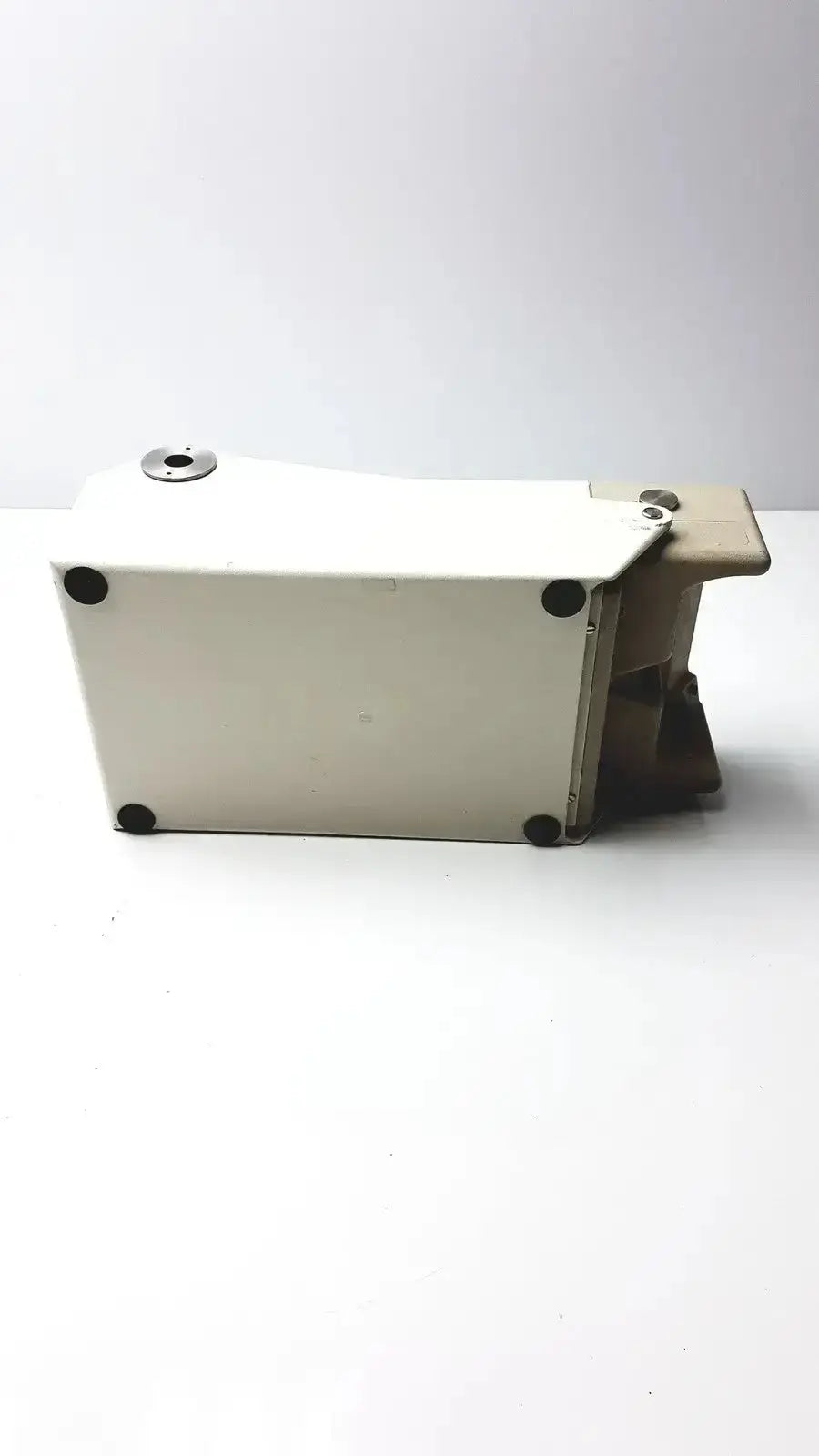 White rectangular metal Titmus Optical II vision tester box with black circular feet and a silver-toned top cap