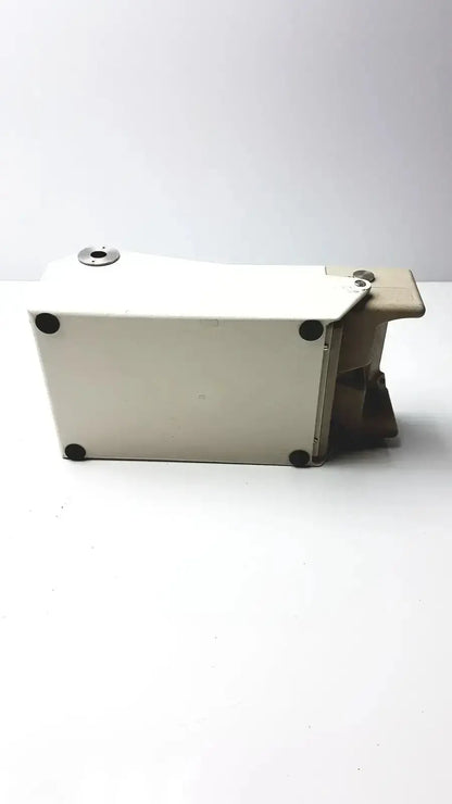 White rectangular metal Titmus Optical II vision tester box with black circular feet and a silver-toned top cap