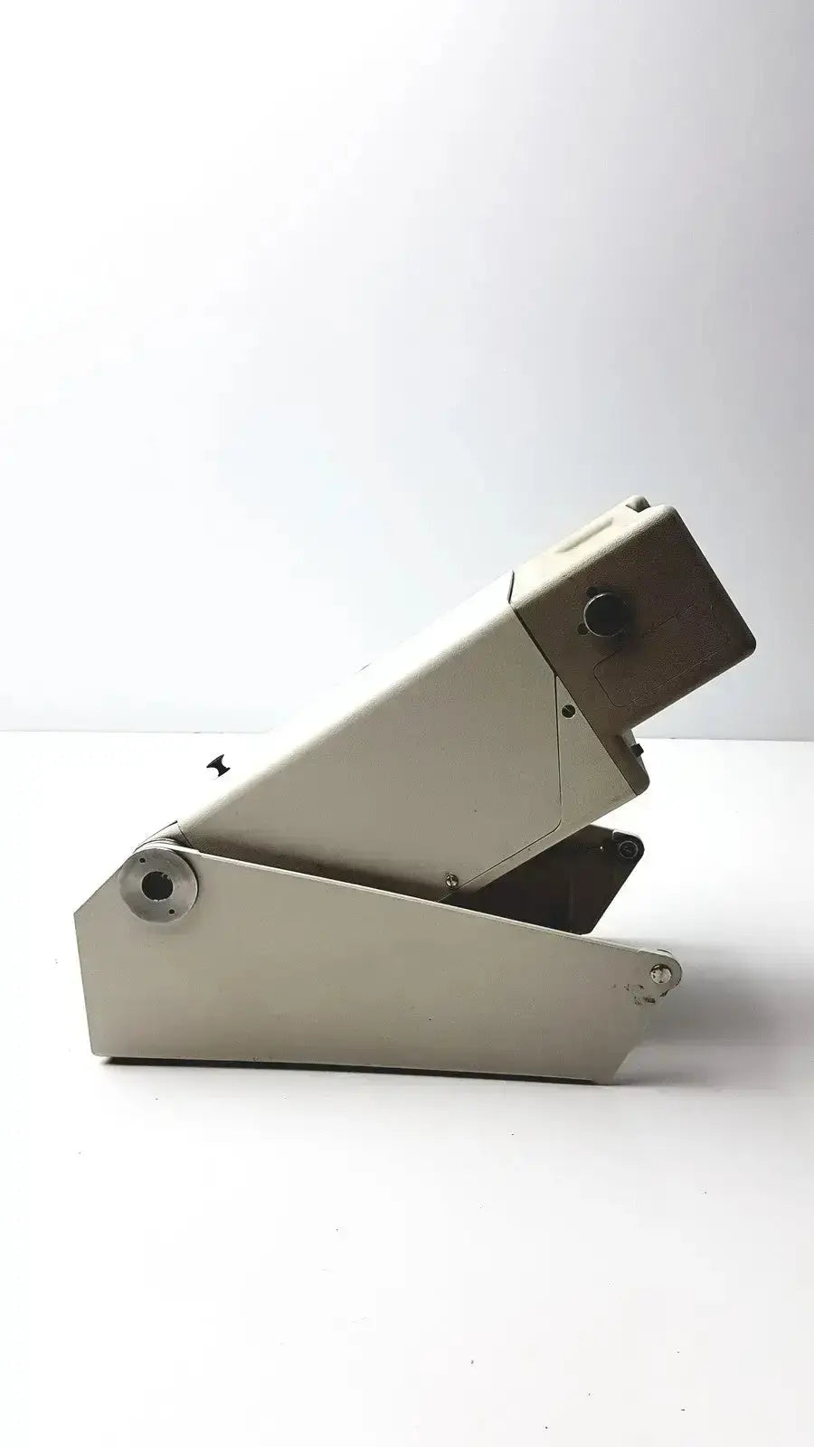Beige metal industrial-grade paper cutter with sturdy hinge and circular adjustment knobs for Titmus Optical II vision tester