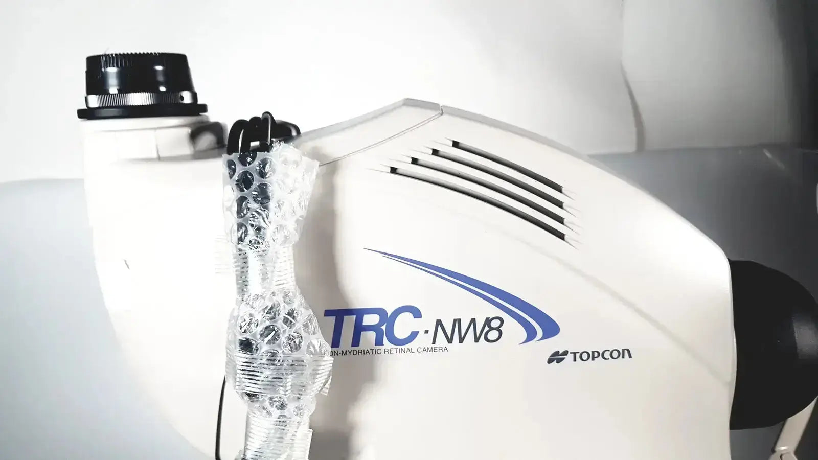 White topcon trc-nw8 non mydriatic retinal camera with blue branding and black ventilation slits used medical equipment for sale