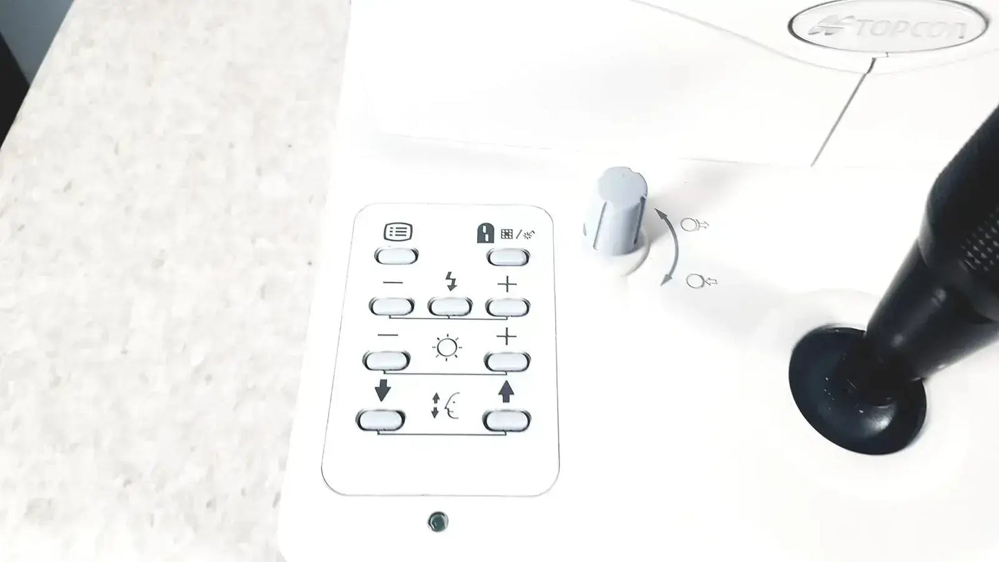 White rectangular remote control with black buttons and green indicator light for topcon trc-nw8 retinal camera used medical equipment for sale