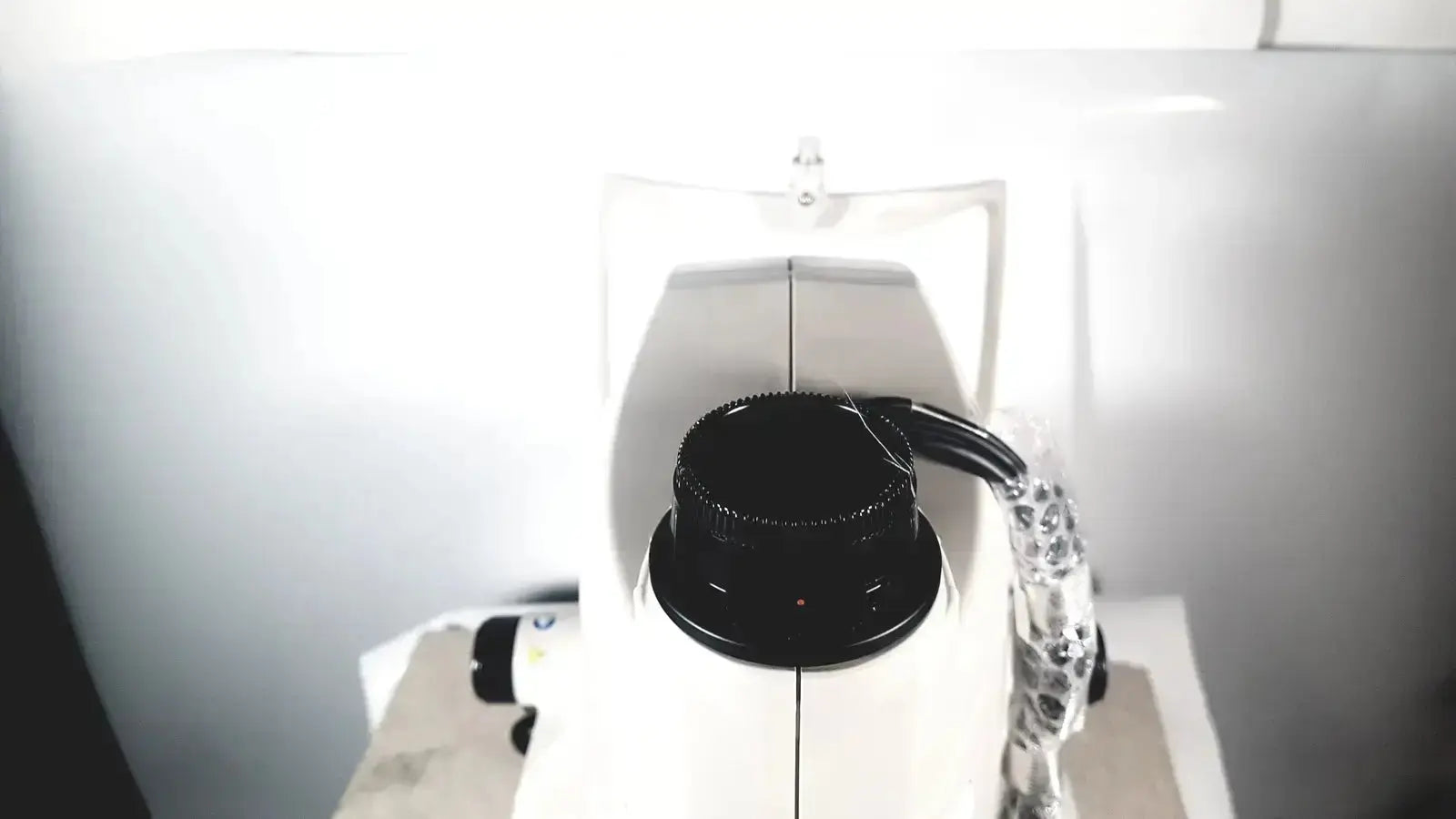 White topcon trc-nw8 retinal camera with black textured focusing knob and clear plastic-coated cable for medical use