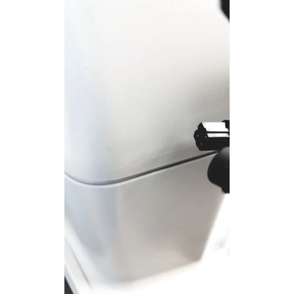A sleek, minimalist white refrigerator with a smooth finish and a subtle silver handle.