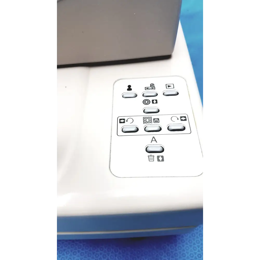 White plastic control panel with gray buttons and black icons, featuring a central ’a’ button surrounded by function symbols.