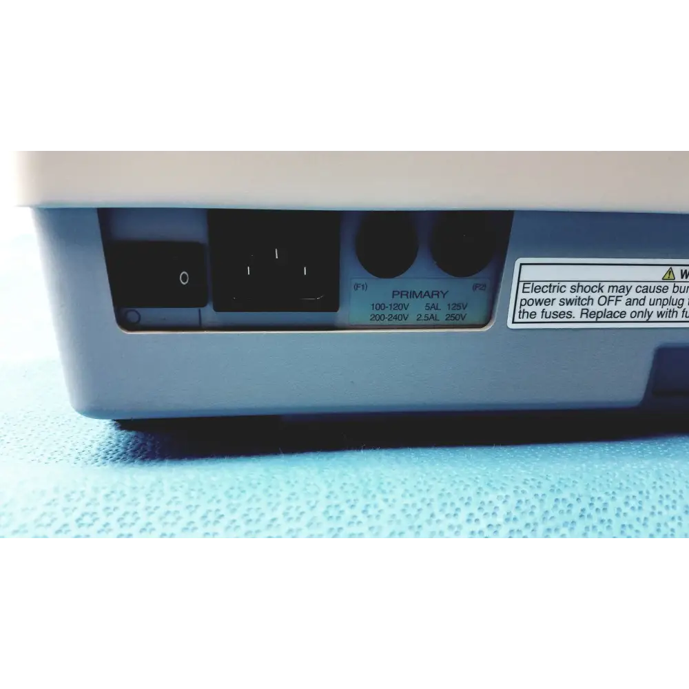 Light gray plastic power supply unit with black input socket and labeled voltage specifications.