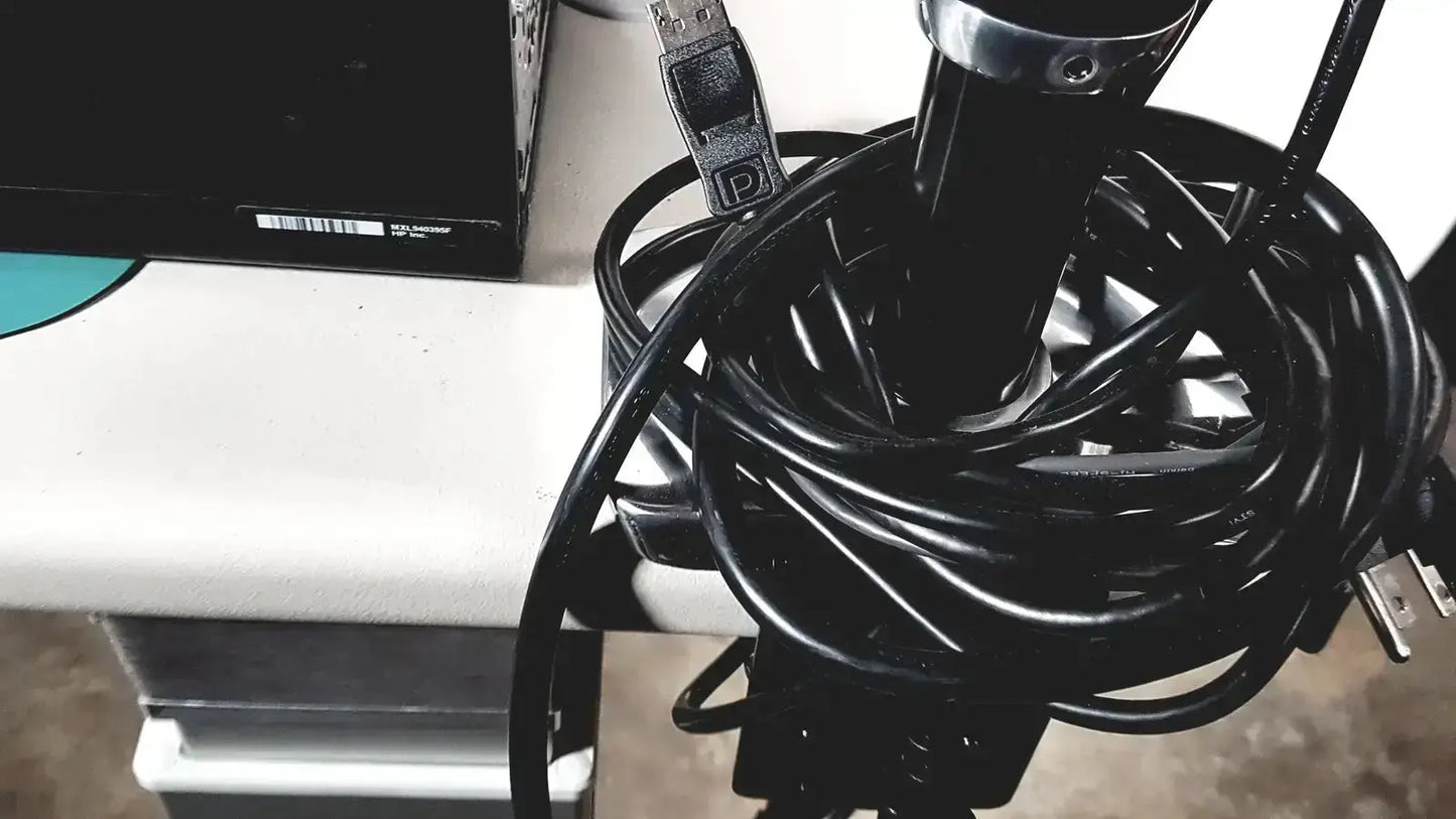 A coiled black USB cable with silver connector and label for Topcon TRC NW8 retinal camera system
