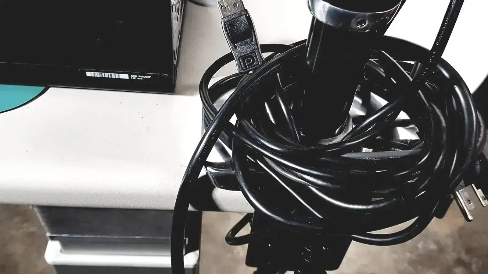 A coiled black USB cable with silver connector and label for Topcon TRC NW8 retinal camera system