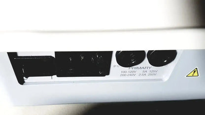 Rear panel of white topcon trc nw8 retinal camera showing black power input ports and voltage specifications label