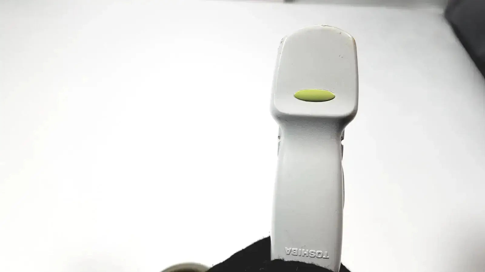 White toshiba handheld barcode scanner with lime green oval button for use with ultrasound transducer probe