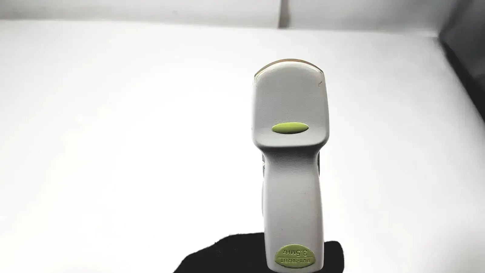 Gray handheld barcode scanner with green button and label shown with toshiba pvt 382bt ultrasound transducer probe