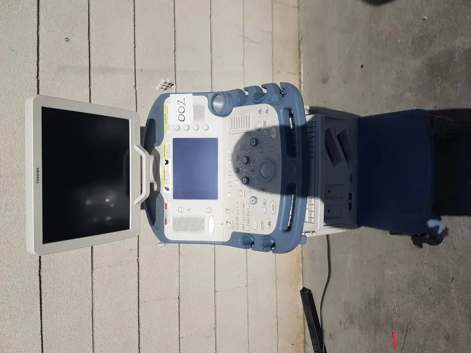 Toshiba Xario XG SSA-660A diagnostic ultrasound machine with white and blue console, multiple buttons, and touchscreen display