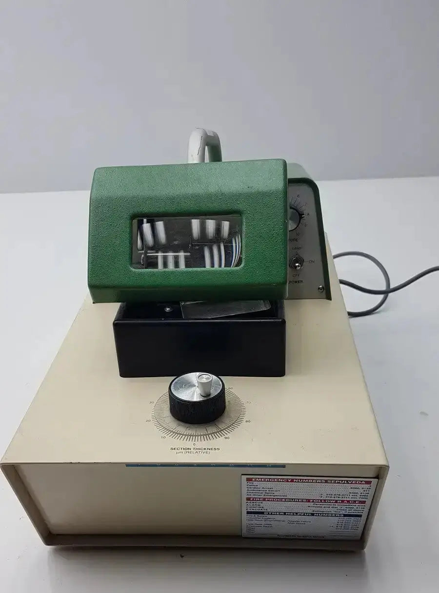Green and beige metal thickness gauge with transparent window on black base in tpi vibratome series 1000 sectioning system