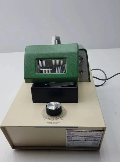Green and beige metal thickness gauge with transparent window on black base in tpi vibratome series 1000 sectioning system
