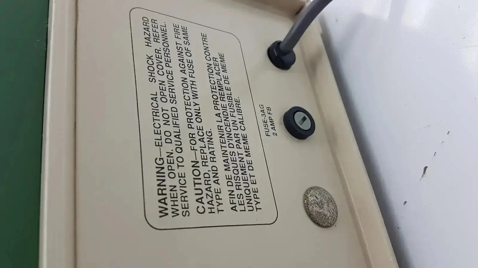 Beige electrical panel with black fuse and warning label on the back of the tpi vibratome series 1000 sectioning system