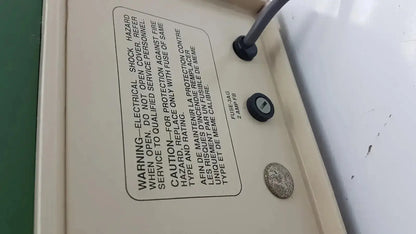 Beige electrical panel with black fuse and warning label on the back of the tpi vibratome series 1000 sectioning system