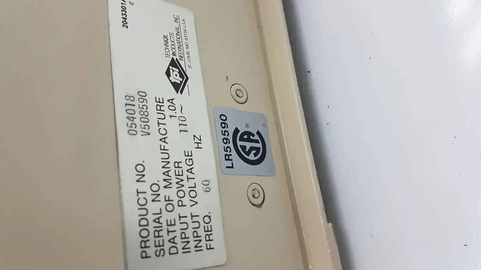 Beige industrial power supply unit with white technical label and silver srd certification on the back of tpi vibratome series 1000