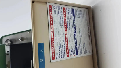 Beige metal emergency equipment box with emergency numbers label on tpi vibratome series 1000 sectioning system