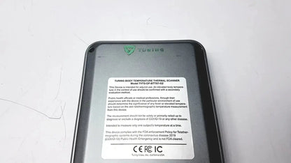 Black plastic turing body temperature thermal scanner with white label showing model number and regulatory information