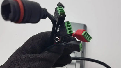 Black plastic cable connector hub with green and red terminal blocks on the back of turing body temperature thermal scanner model tvts-op-btts 7-g2