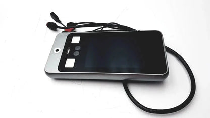 Silver-framed smartphone with black screen and wired earphones resting on turing body temperature thermal scanner model tvts-op-btts 7-g2