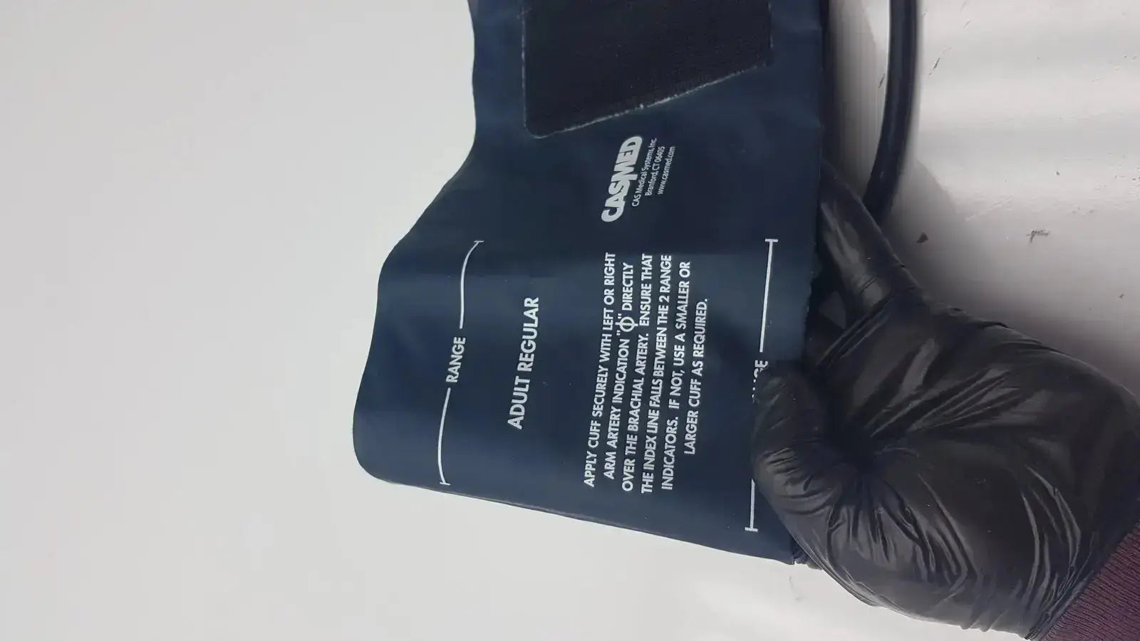 Dark blue latex free blood pressure cuff by cashmed with white printed instructions for accurate blood pressure measurement