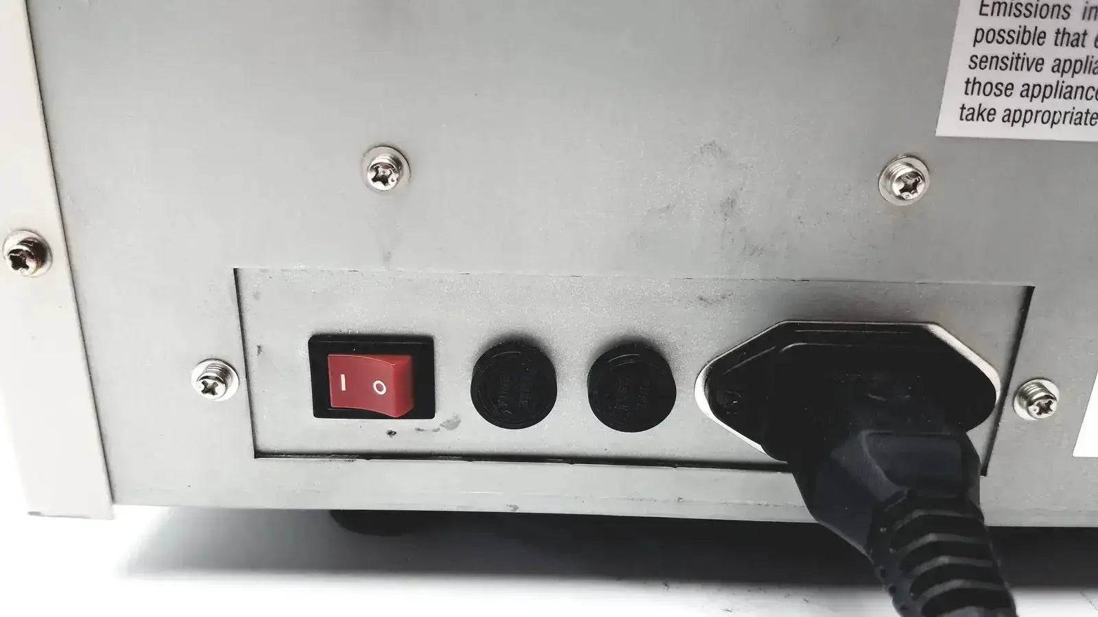 Black power cord plugged into the back of a silver ultramark bio-rad microplate imaging system with red on/off switch and ports