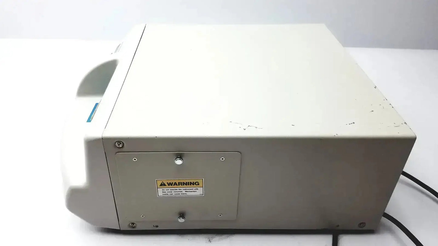 Beige plastic medical centrifuge with warning label and screws on side panel of ultramark bio-rad microplate imaging system