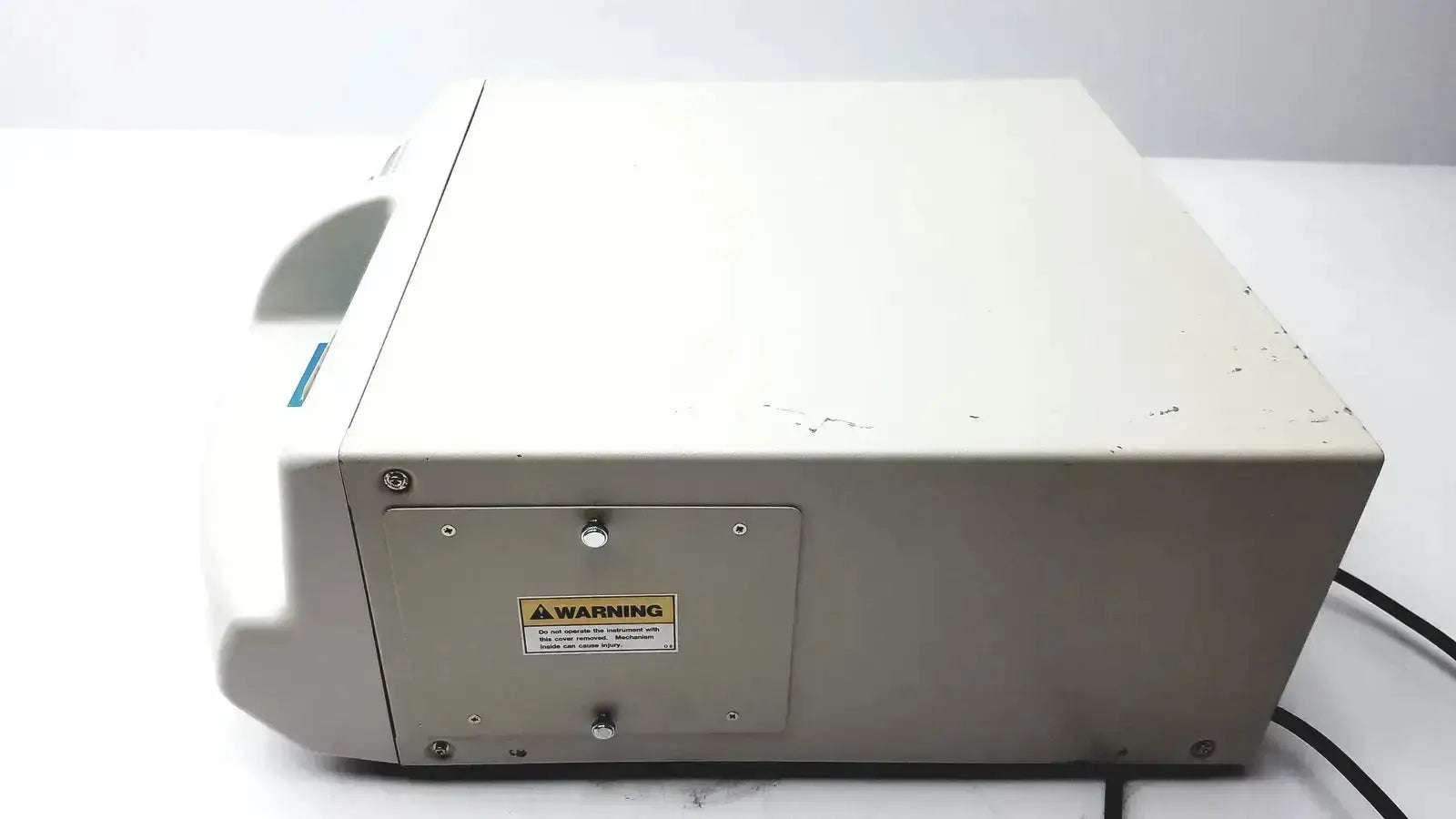 Beige plastic medical centrifuge with warning label and screws on side panel of ultramark bio-rad microplate imaging system