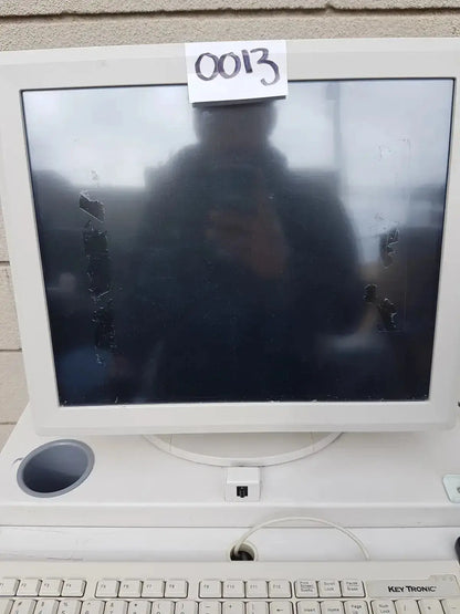 White plastic crt monitor with black scratched screen and integrated white key tronic keyboard on multilab series ii lhs vascular cart