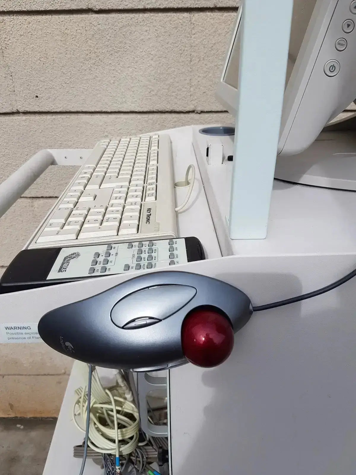 Gray logitech trackball mouse with red ball and ergonomic design on multilab series ii lhs vascular cart extras