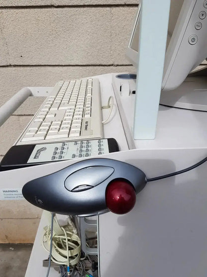 Gray logitech trackball mouse with red ball and ergonomic design on multilab series ii lhs vascular cart extras