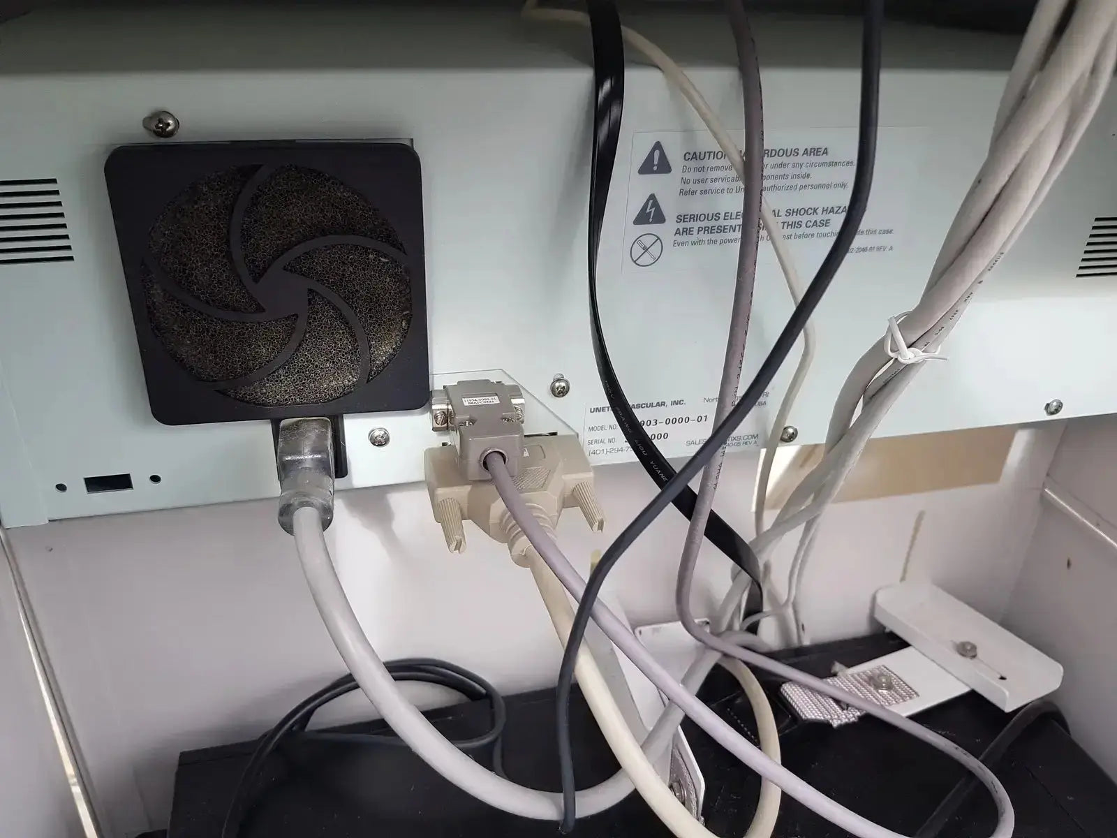 Back view of black square fan with dark textured grille on white electronic device of unetix series ii lhs vascular cart