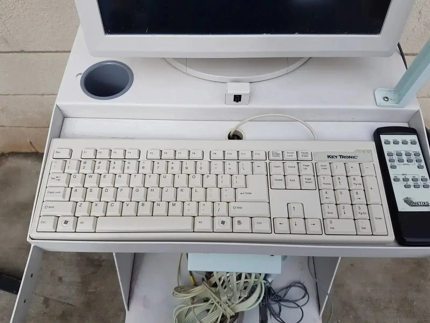 White plastic key tronic keyboard with beige keys on multilab series ii lhs vascular cart integrated desk unit