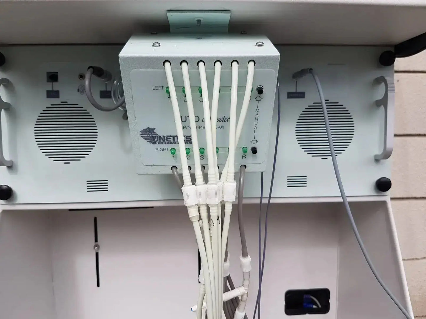 White plastic medical device with six cables connected shown from the back on multilab series ii lhs vascular cart