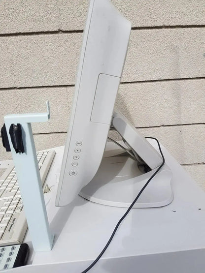 White plastic monitor with integrated stand and side control buttons on multilab series ii lhs vascular cart