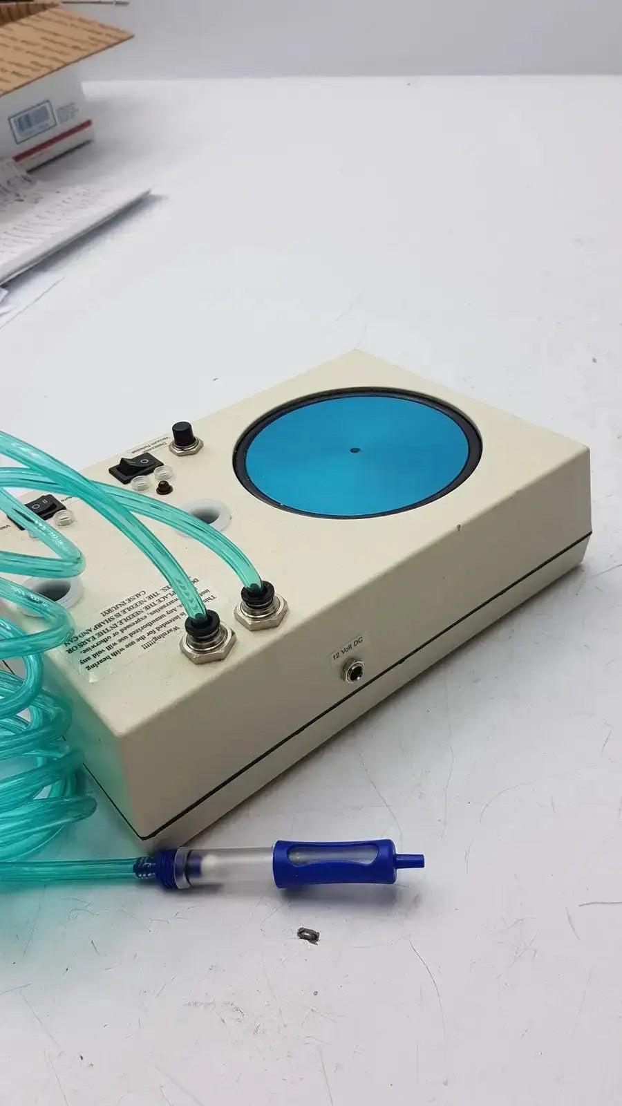 Beige rectangular Unicorn Medical MD11684 desiccator vacuum system with circular blue window and teal tubing connected to fittings
