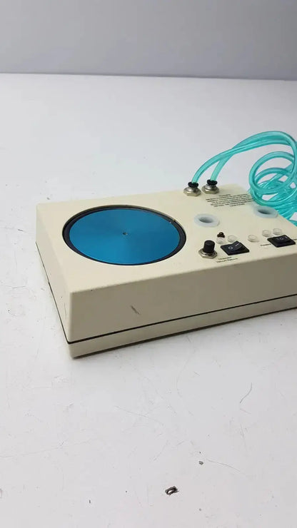 Beige rectangular unicorn medical md11684 desiccator vacuum with blue circular platform and coiled teal tubing visible