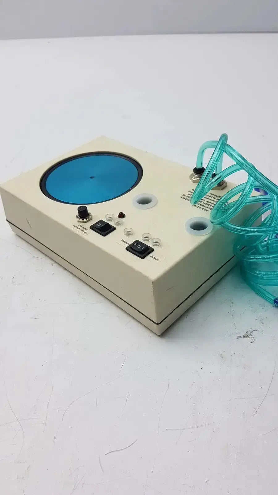Beige rectangular unicorn medical md11684 desiccator vacuum system with blue circular component and teal coiled tubing