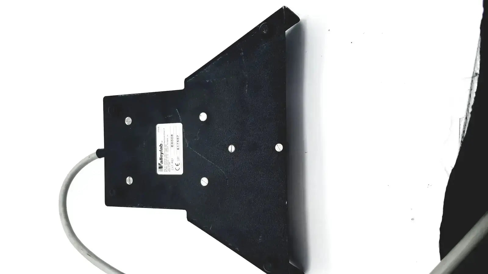 Black plastic mounting bracket with white label and silver screws on valleylab covidien e6008 electrosurgical monopolar footswitch
