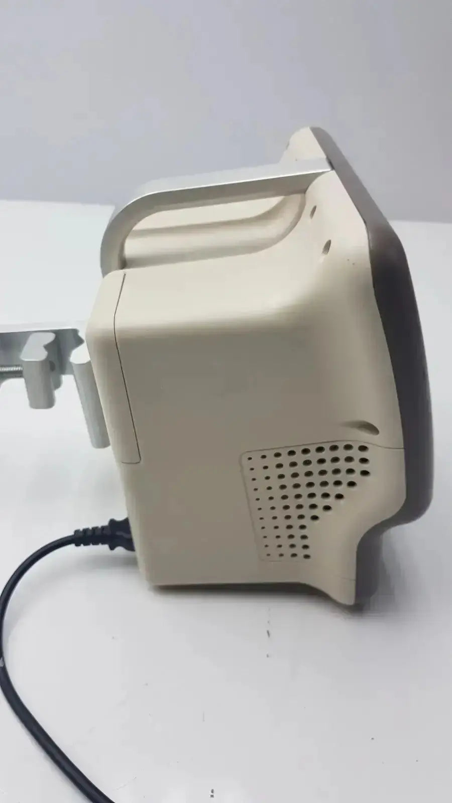 Beige and black vasamed sensilase pressure testing monitor with curved handle and ventilation grille connected to power cable