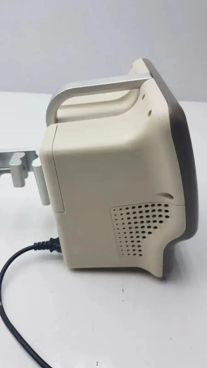 Beige and black vasamed sensilase pressure testing monitor with curved handle and ventilation grille connected to power cable