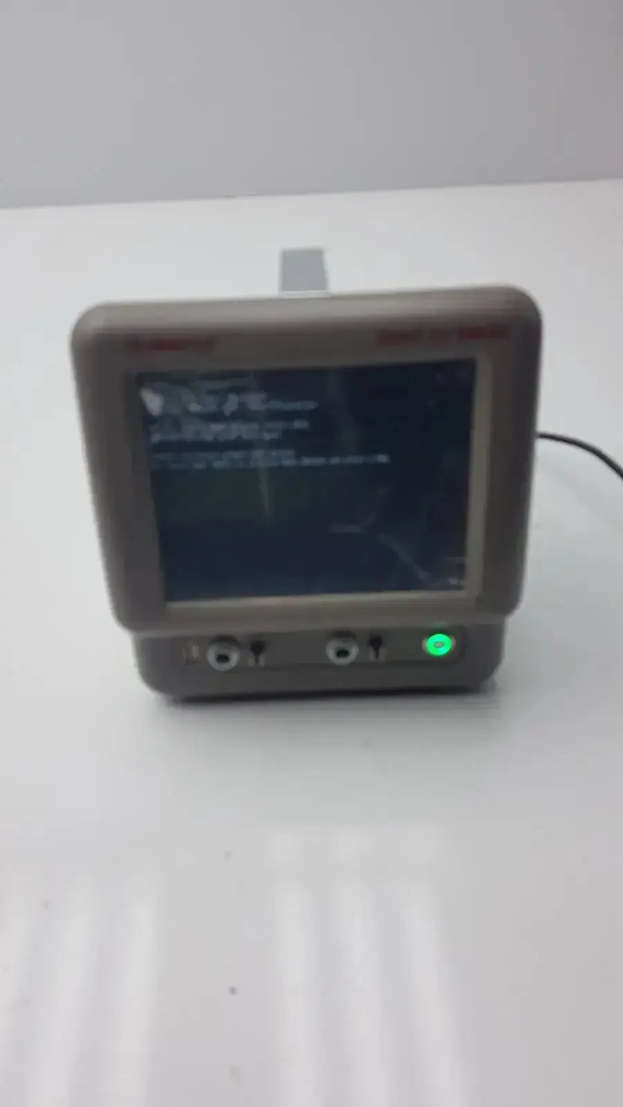 Gray plastic vasamed sensilase pressure testing monitor with dark screen, green power light, and multiple input ports