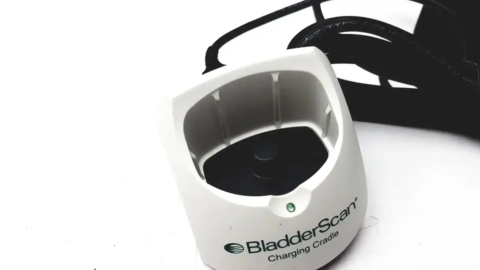 White plastic Verathon 0570-0155 bladderscan charging cradle with black interior and green indicator light for charging