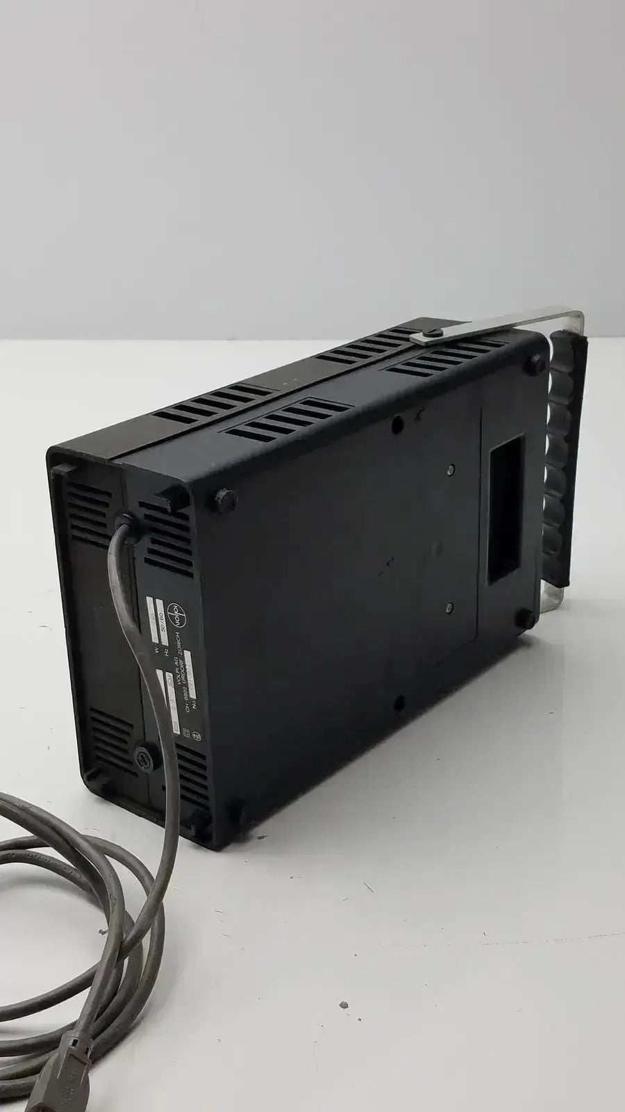 Black rectangular volpi intralux 6000 light source with ventilation slots and coiled power cable 115v 185w back view