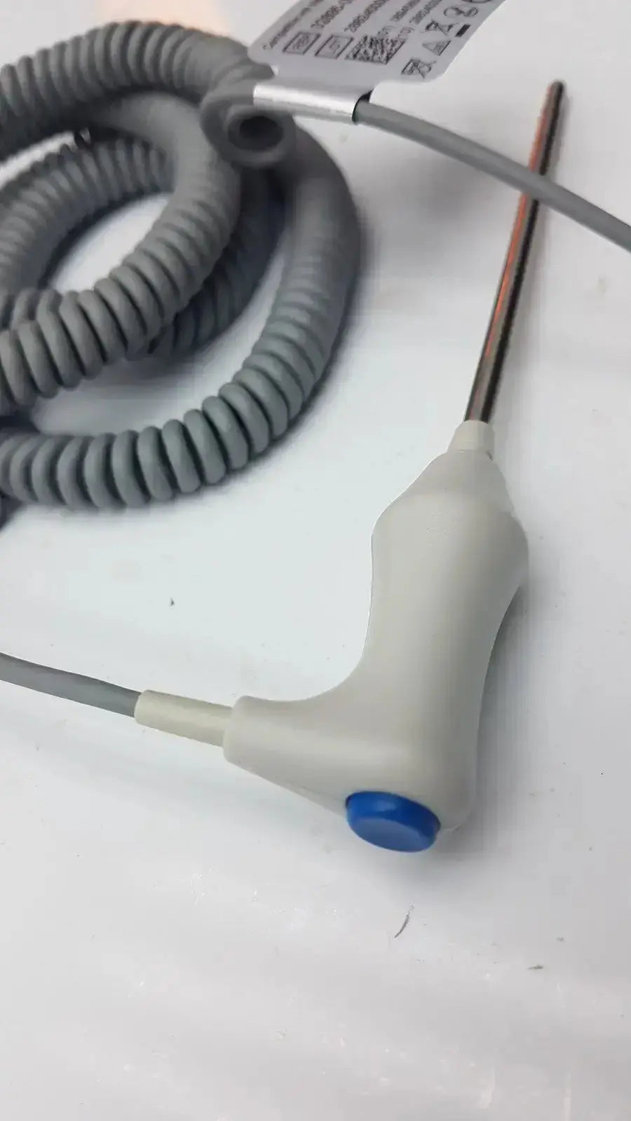 Gray coiled cable connected to a white plastic handle with blue button and metallic probe for welch allyn oral temperature probe