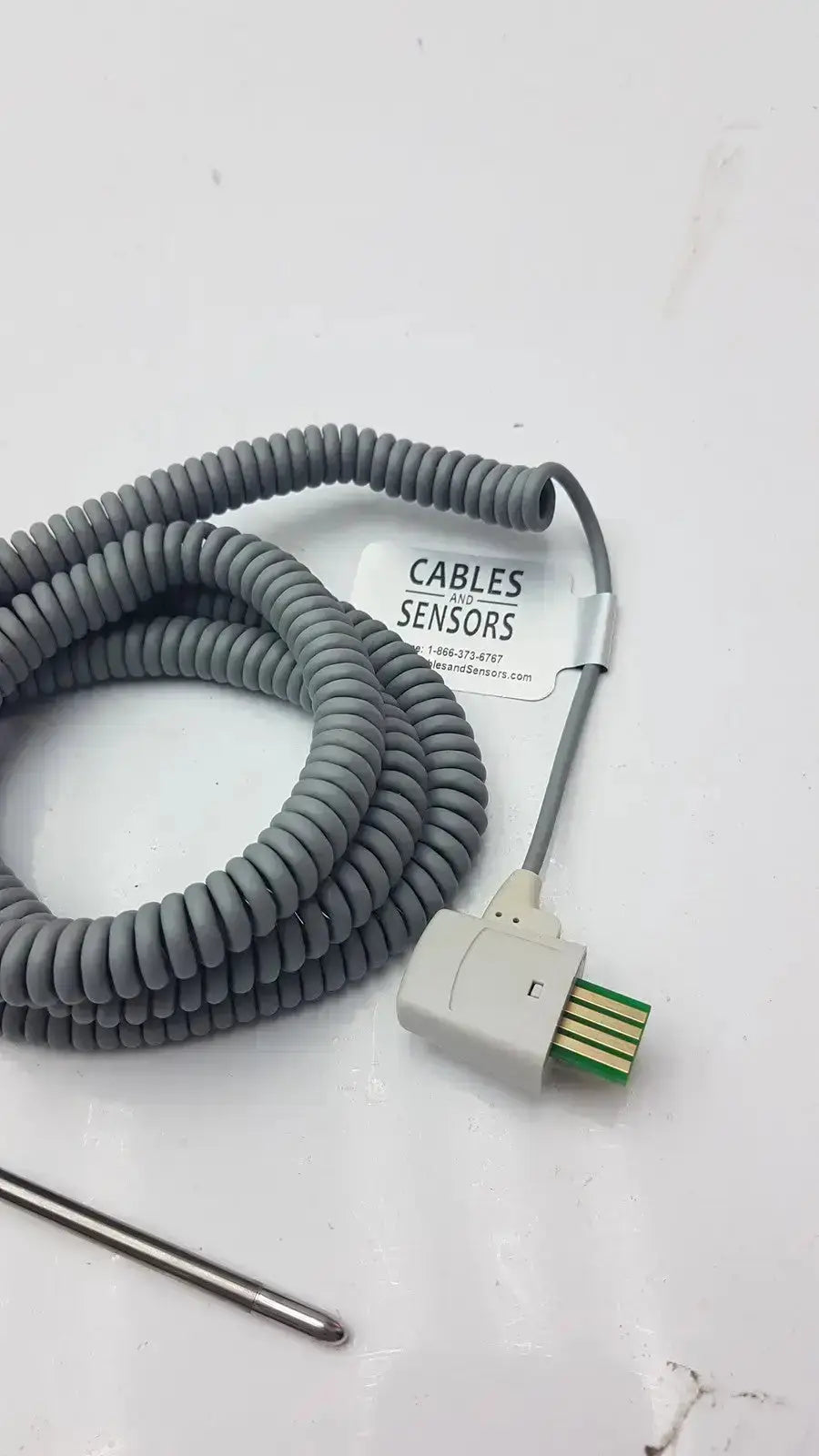 Gray coiled oral temperature probe cable with white connector housing and green pins labeled cables and sensors for Welch Allyn